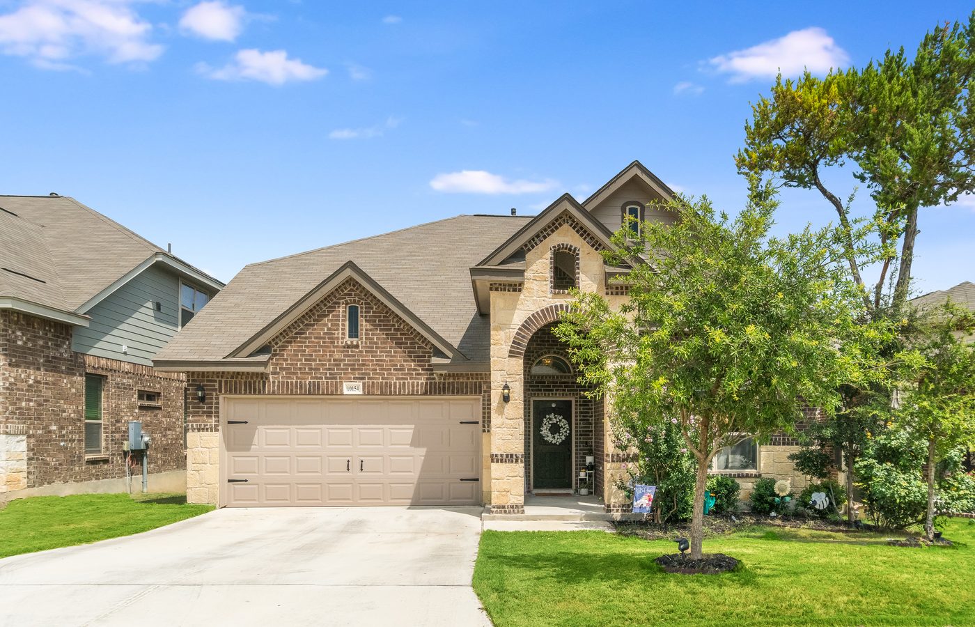 Two-person garage door crew installing a smart opener and safety sensors